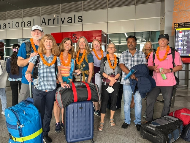      Group of people at an airport, some with garlands.
  