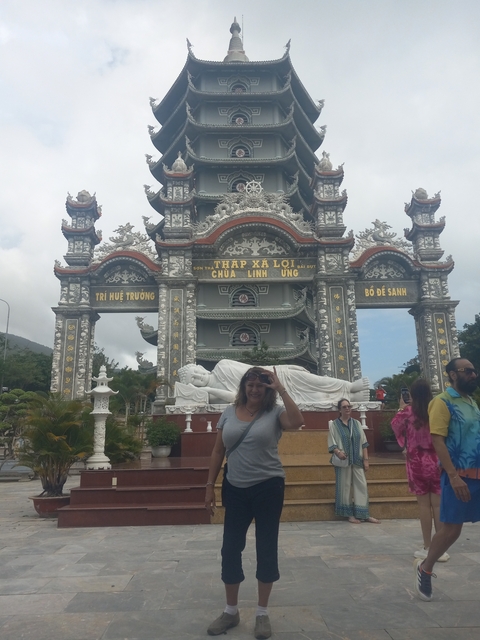 Group of people in front of an ornate gateway at a temple.