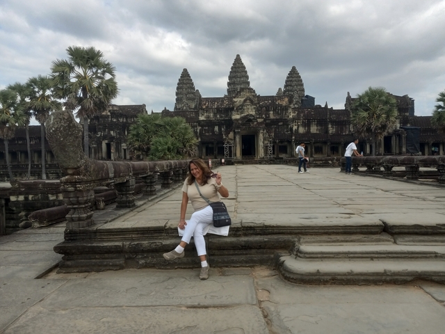       Woman seated at the entrance of an ancient temple.
  