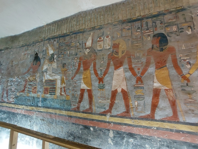 Ancient Egyptian wall carvings and paintings in a tomb.