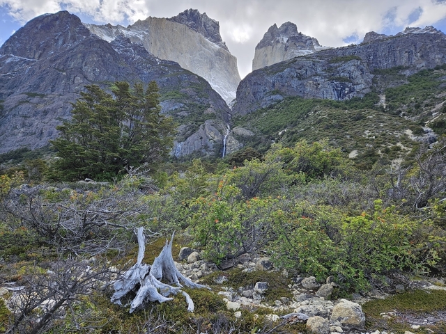 Mountain range with rugged vegetation and distant peaks.