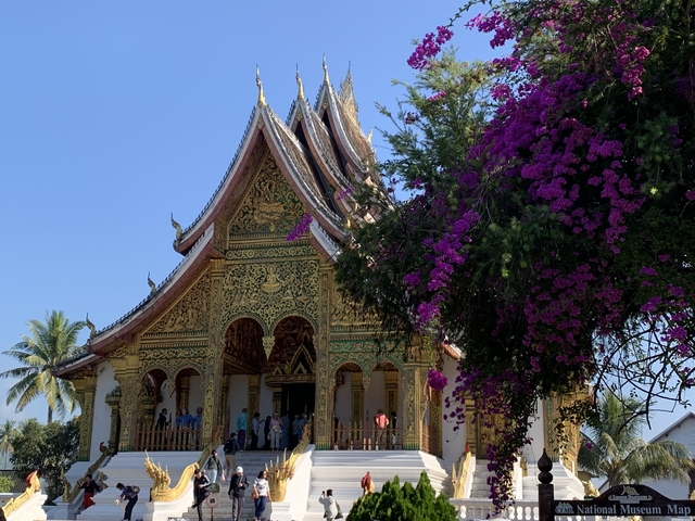 Ornate Buddhist temple with vibrant flowers.