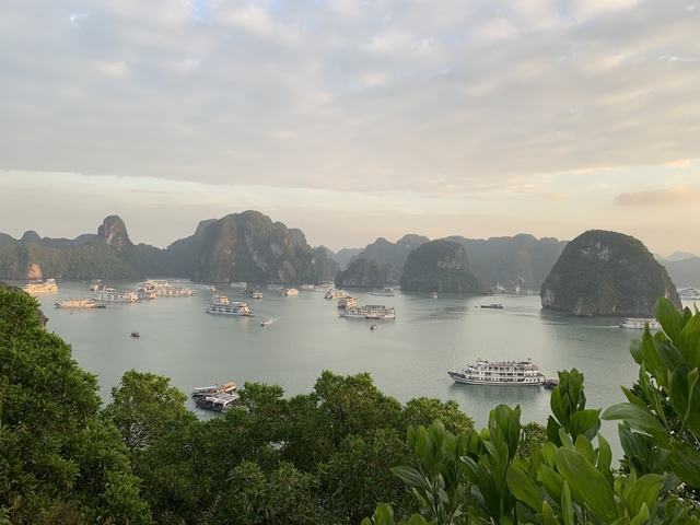       Halong Bay with boats at dusk.
  