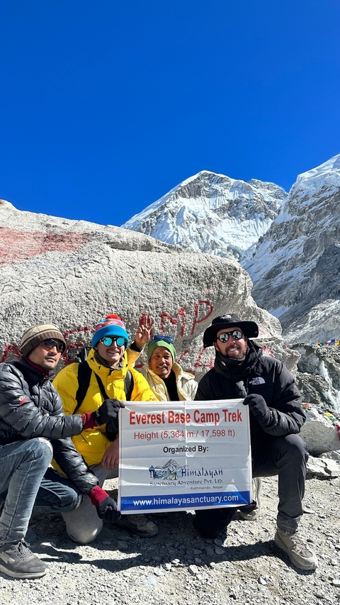 Group of hikers posing in front of a snowy mountain.
