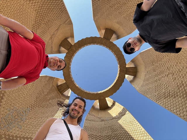       Three people looking up at a circular architectural feature.
  