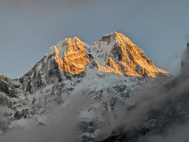       Close-up of a sunlit snow-capped mountain peak.
  