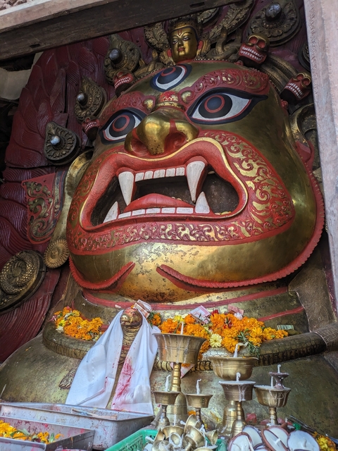       Close-up of an ornate and colorful sculptural face.
  