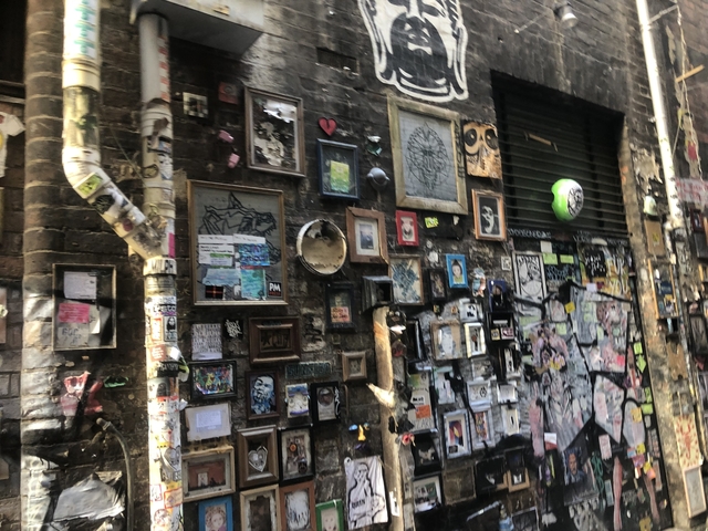       Graffiti and art on a brick wall in an alleyway
  