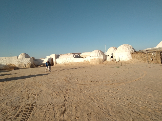 Traditional desert dwellings with people.
