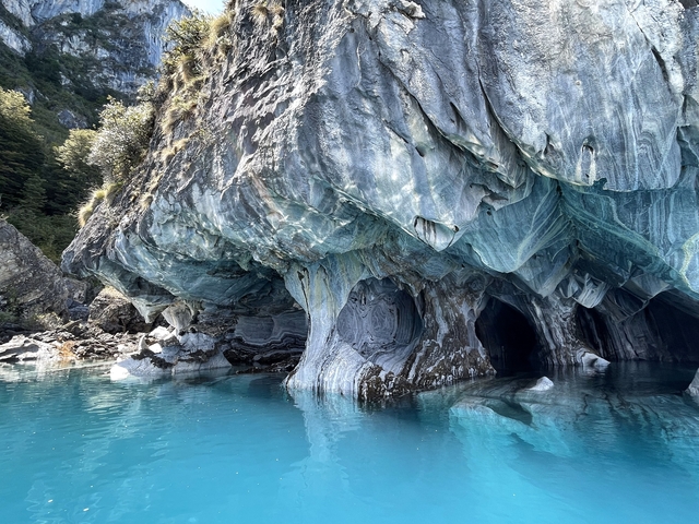 Beautiful cave formations by blue water.