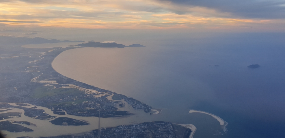 Aerial view of a coastline with a sunset sky