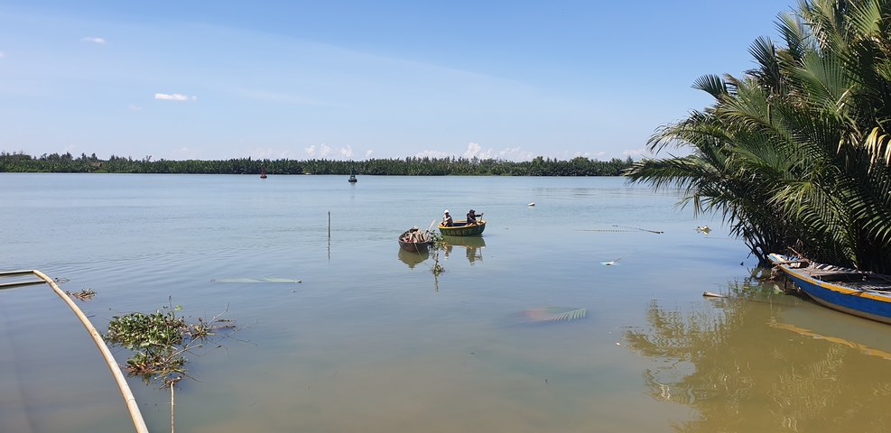 Calm river with a small boat and lush greenery