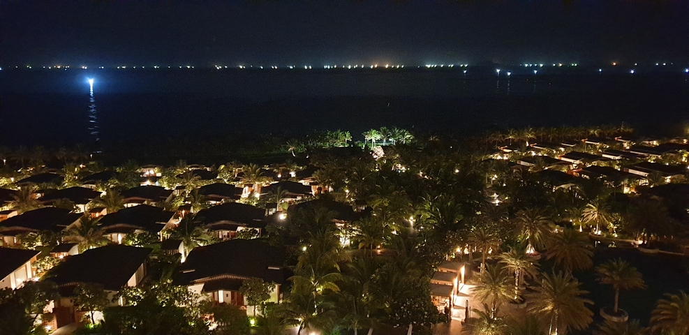       Nighttime view of a resort with lights and water.
  