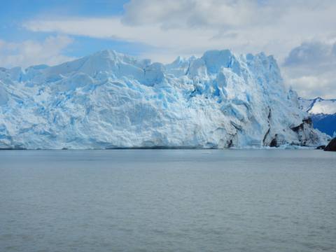 Wide view of a glacier with mountains in the distance.