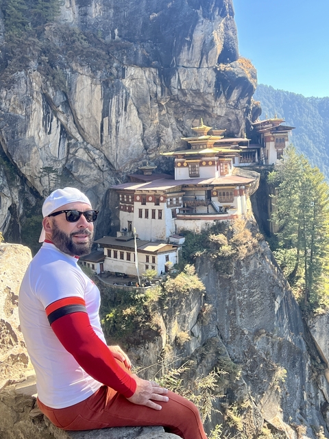       A man standing in front of the Paro Taktsang Monastery.
  