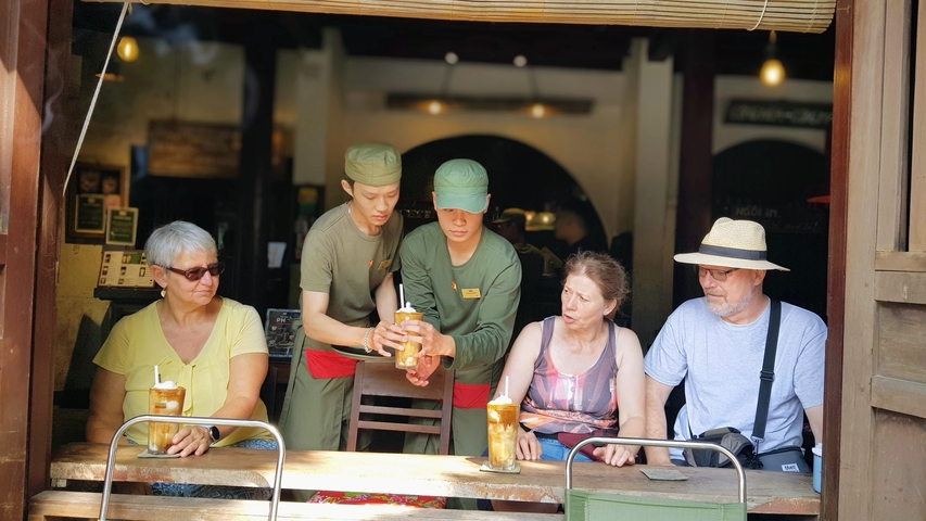 Group of people being served drinks at a cafe