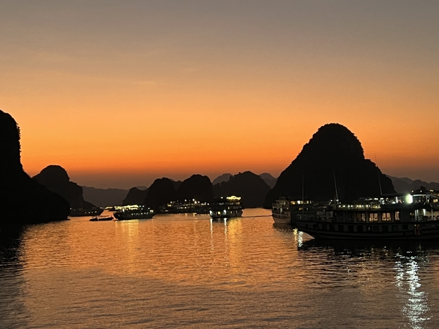       Sunset over Halong Bay with boats and limestone karsts
  