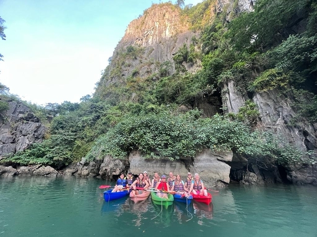       Group of people kayaking in a scenic limestone karst environment
  