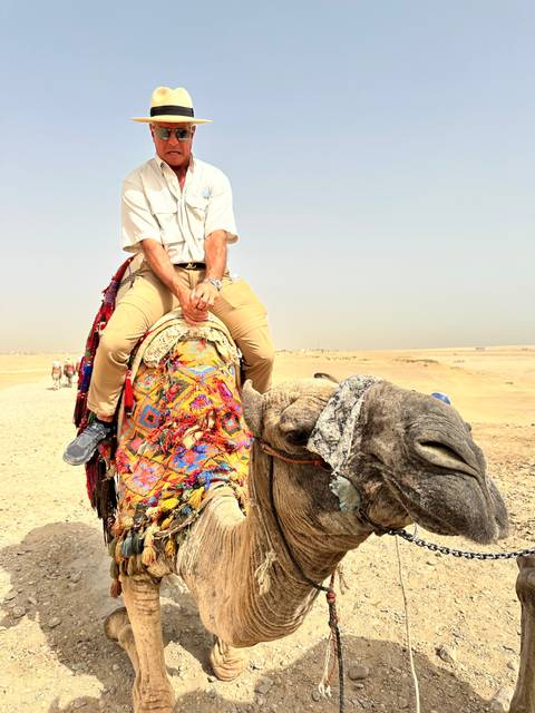 Person riding a camel in the desert.