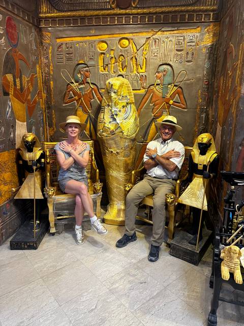 Two people sitting in an Egyptian themed room.