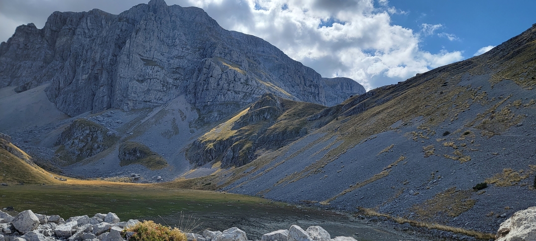       Rocky mountain terrain under a cloudy sky.
  