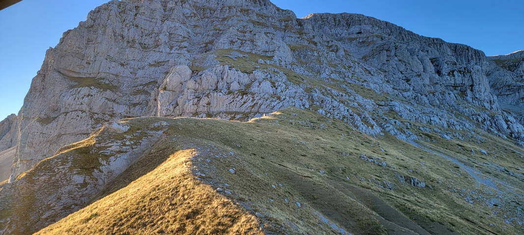       Mountain peak with rocky terrain and a clear sky.
  