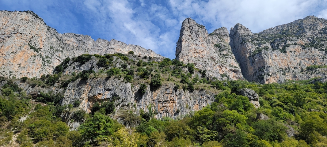 Rocky cliff face against a bright blue sky.