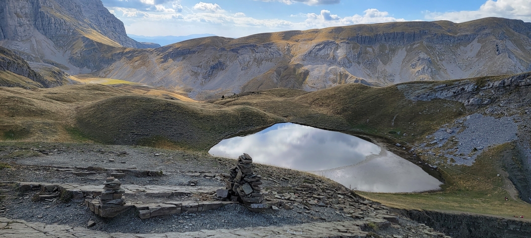       Small mountain lake surrounded by hills.
  