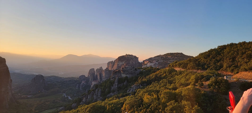       Scenic view of rock formations and hills at sunset.
  