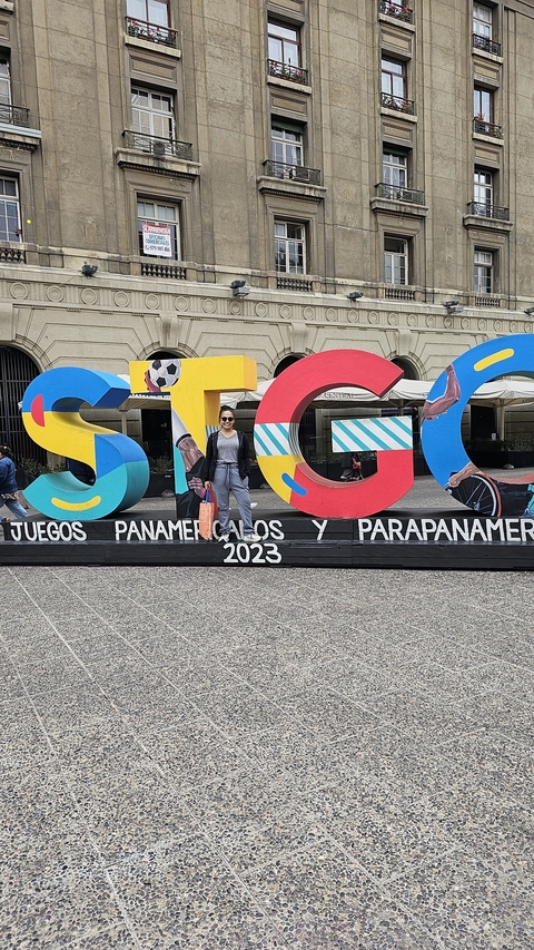 Person posing in front of colorful letters STGO.