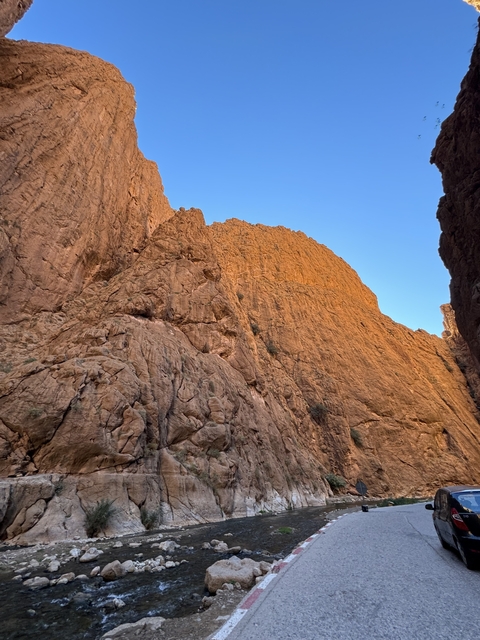 Tall rock formations in Todra Gorge under a blue sky.