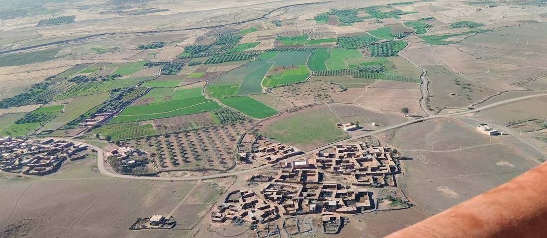       Aerial view of a village and agricultural fields.
  