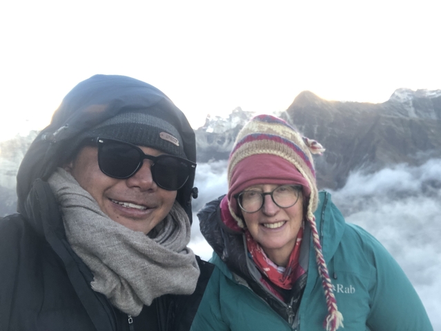       Two people in winter clothing with mountains in the background.
  