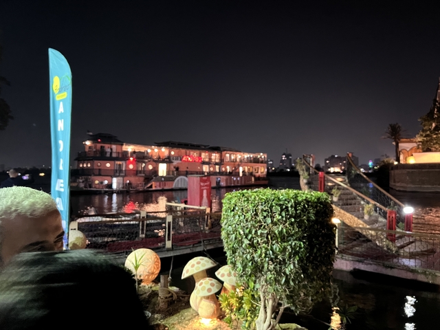 A night scene with a lit boat on a river.