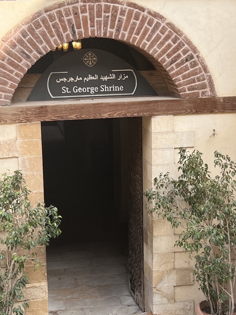 An entrance to a historical site with plants nearby.