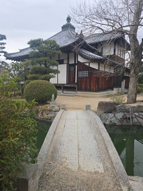       Traditional Japanese building with a bridge over water.
  