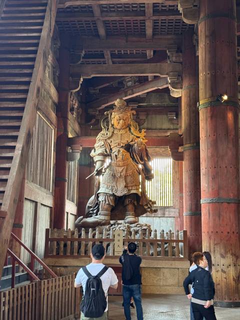A wooden statue of a warrior inside a temple.