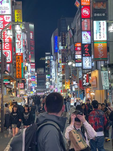 Bustling city street filled with neon signs at night