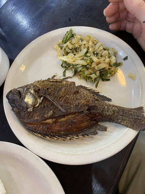 Plate with a cooked fish and some vegetables.