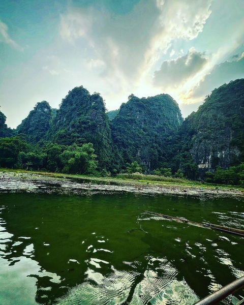 Rock formations and a river in a lush green landscape.