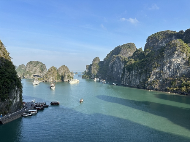       Aerial view of boats in Halong Bay surrounded by limestone karsts.
  
