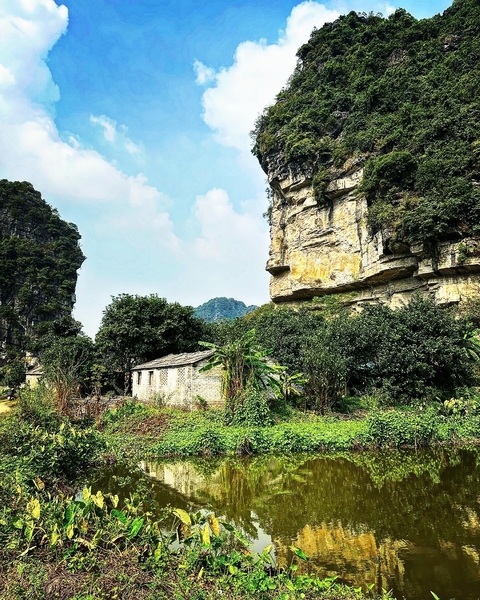       Old brick structure amidst rock formations and foliage.
  