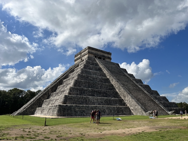       The pyramid at Chichen Itza with people around.
  