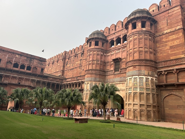       Red sandstone fort with visitors.
  