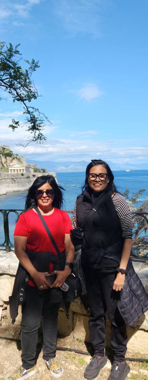       Two women posing by the sea.
  