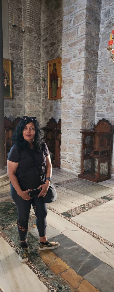      Woman sitting inside a stone building.
  