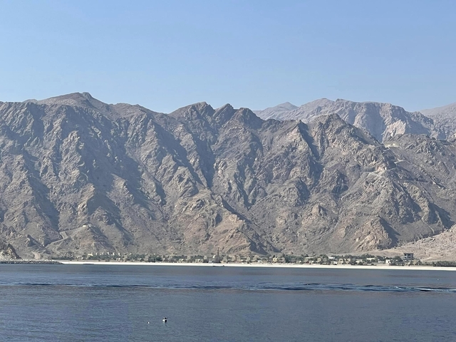 Coastal desert landscape with mountains in the background.