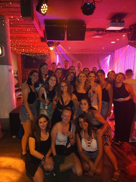 Large group of people posing indoors, possibly at an event.