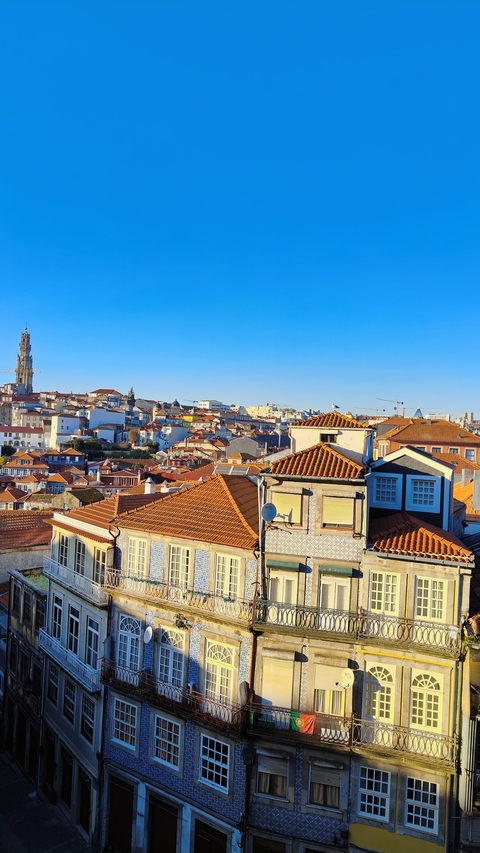       Overview of a hilly town with red-roofed buildings.
  
