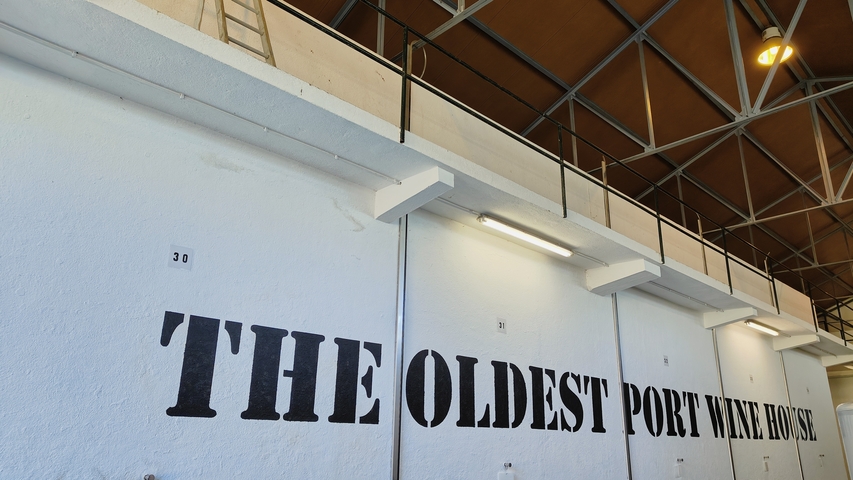       Interior of a port wine cellar with visible signage.
  